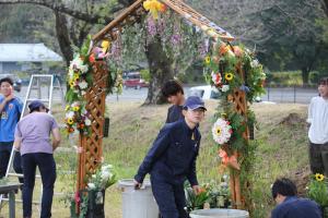 ゲートを花で飾り付ける学生